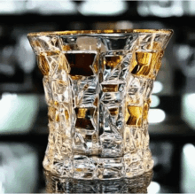 a clear glass with a gold rim filled with liquid