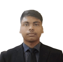 a young man is wearing a suit and tie and looking at the camera .