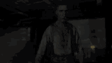 a man in a dirty shirt and suspenders is standing in the dark .