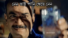 a man with a mustache is smiling and holding a glass with a caption in another language .