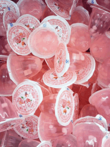 a pile of pink jelly cups with a label that says ' cherry ' on it