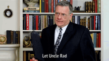 a man in a suit and tie is standing in front of a bookshelf with the words let uncle rad below him