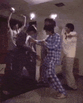 a group of people are dancing in a room while wearing pajamas