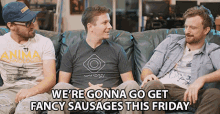 three men are sitting on a couch with the words we 're gonna go get fancy sausages this friday at the bottom