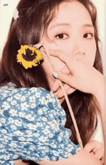 a close up of a woman wearing a sunflower in her hair .