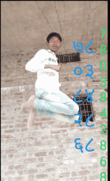 a boy wearing sunglasses jumps in the air in front of a brick wall with numbers around him