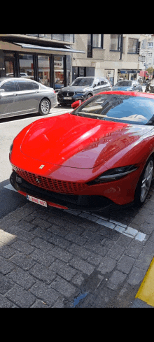 a red ferrari sports car is parked on the side of the road in a parking lot