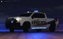 a white police truck is parked on a dock at night