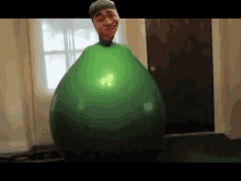 a green balloon with a man 's head sticking out of it .