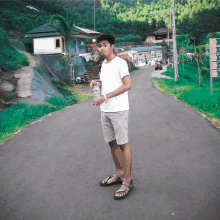 a man standing on a road holding a bottle