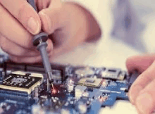 a person is soldering a motherboard with a soldering iron .