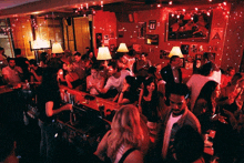 a crowd of people are gathered at a bar with a sign on the wall that says ' a ' on it