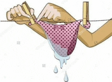 a woman is hanging a pink polka dot bikini on a clothesline .