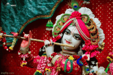 a statue of krishna playing a flute with a peacock feather in his hair