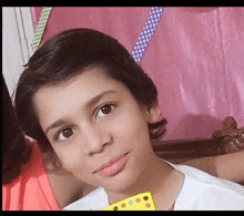 a close up of a young boy 's face with a pink background .