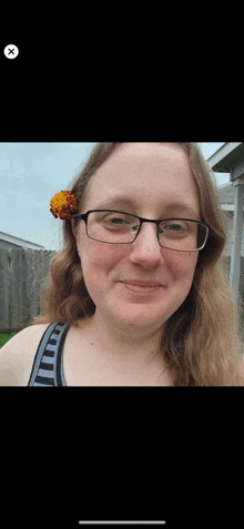 a woman wearing glasses with a flower in her hair