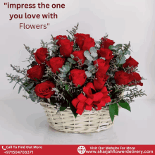 a bouquet of red roses in a white basket with a red bow