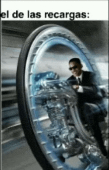 a man in a suit is riding a wheeled vehicle with the words el de las recargas below him .