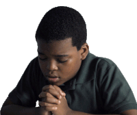 a young boy is praying with his hands folded