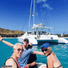 a group of people are posing for a picture in front of a boat that says ' aoxone ' on the side