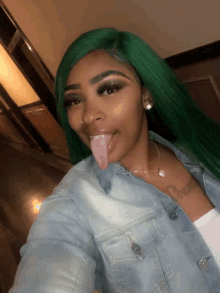 a woman with green hair sticks her tongue out