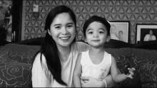 a black and white photo of a woman holding a young boy