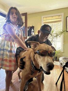 a man wearing a hat that says ' california ' on it is petting a dog