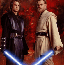 two men standing next to each other holding lightsabers .