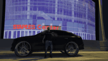 a man standing next to a black car in front of a staples center