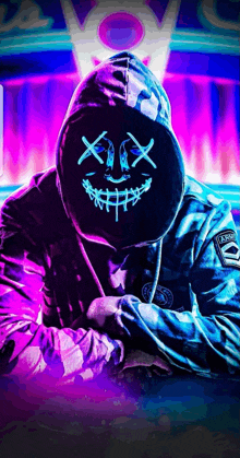 a man wearing a hoodie and a neon mask with a smile on his face .