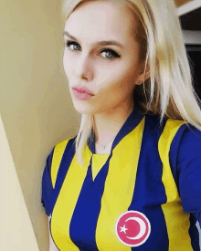 a woman wearing a blue and yellow striped shirt with a crescent moon and star on the front