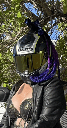 a woman wearing a hjc helmet with purple braids on her head