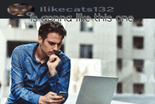 a man is looking at his phone while sitting in front of a laptop with the caption " is gonna like this one "