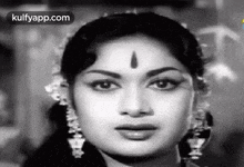 a close up of a woman 's face with a bindi on her forehead in a black and white photo .