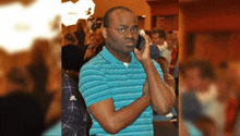 a man in a blue striped shirt is talking on his cell phone