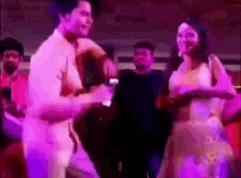 a man and a woman are dancing in front of a crowd of people .