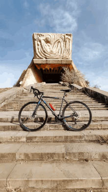 a bicycle is parked on a set of stairs in front of a statue that says " obelisco "