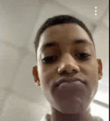 a young boy is making a funny face in a video call .