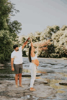 a man and a pregnant woman are dancing in the water