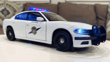 a white toy police car with the word state on the side