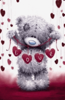 a teddy bear is holding a string of hearts with the word love written on them