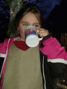 a little girl is drinking from a mug that says ' christmas time ' on it