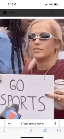 a woman wearing sunglasses holds up a sign that says go sports