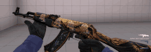 a person wearing black gloves holds a gun with a gold design on it