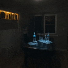 two bottles of grey goose vodka sit on a table in a dark room