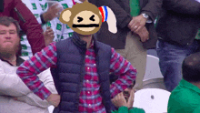 a man in a plaid shirt has a monkey head on his head