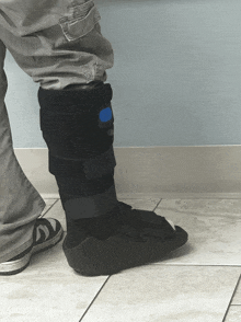 a person wearing a boot with a blue button on the side