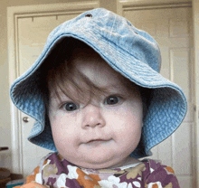 a baby wearing a blue hat is making a face