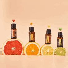 four bottles of doterra essential oils are stacked on top of grapefruit