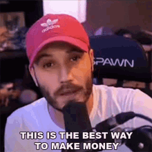 a man wearing a red hat is talking into a microphone and says this is the best way to make money